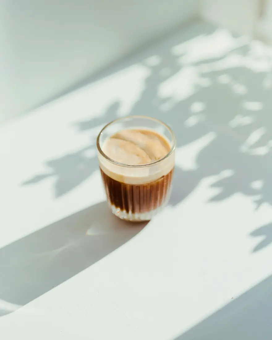 Glass of espresso with milk in morning light